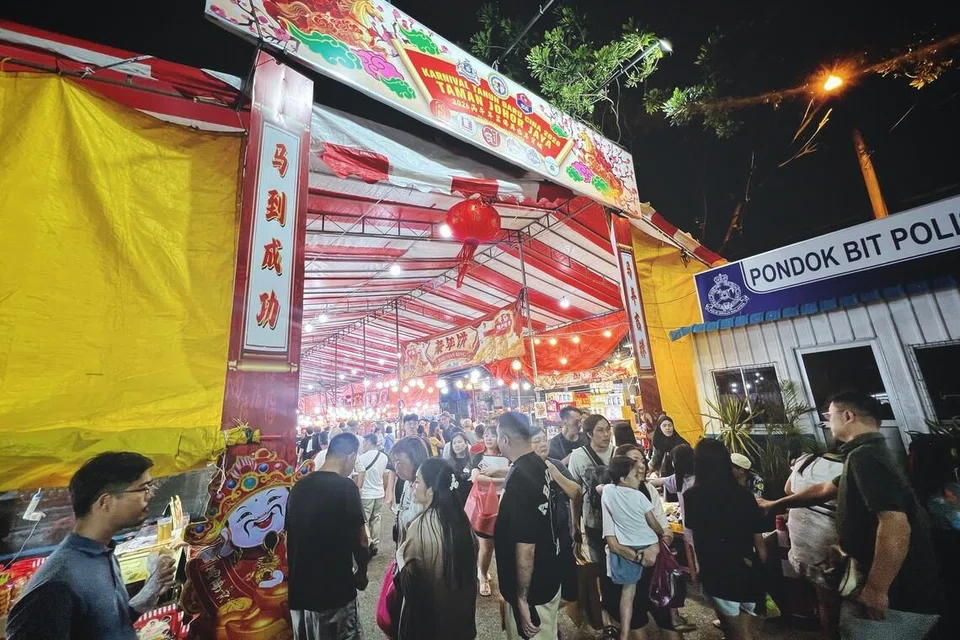 Shoppers walking through stalls at a Chinese New Year bazaar in Johor Bahru